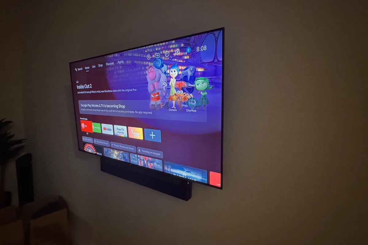 Wall-mounted smart TV displaying Inside Out 2 with streaming apps